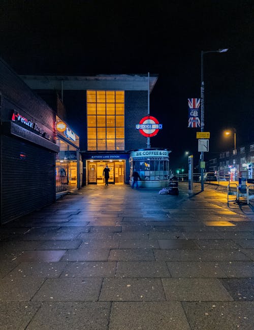 This image shows a moving train arriving at an underground station platform with beige and brown exterior, captured in motion blur indicating high speed. The platform features beige tiled flooring wit